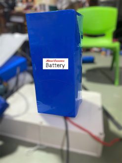 A Lithium ion battery pack in the making with dark blue heatshrink cover, electrical cords black and red connected.